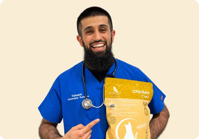 Faheem, veterinary surgeon, holding a bag of Hurayra chicken cat food
